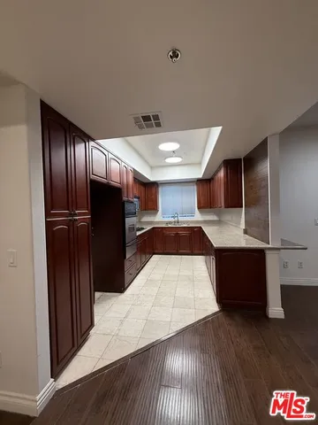 a kitchen with stainless steel appliances kitchen island granite countertop a refrigerator and a sink