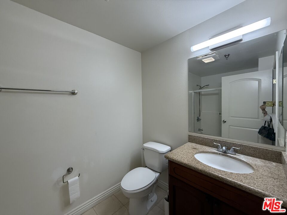962 Gramercy Drive, Unit 102 Los Angeles, CA 90019 - Photo 18 of 20 a bathroom with a granite countertop toilet sink and mirror