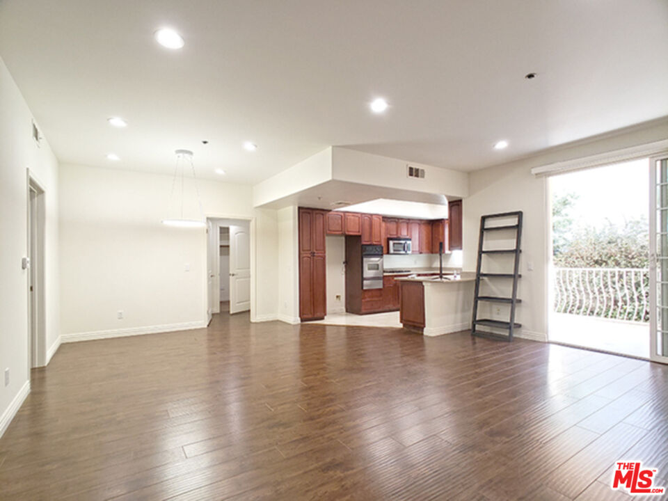 962 Gramercy Drive, Unit 102 Los Angeles, CA 90019 - Photo 2 of 20 an open space with kitchen view and a refrigerator