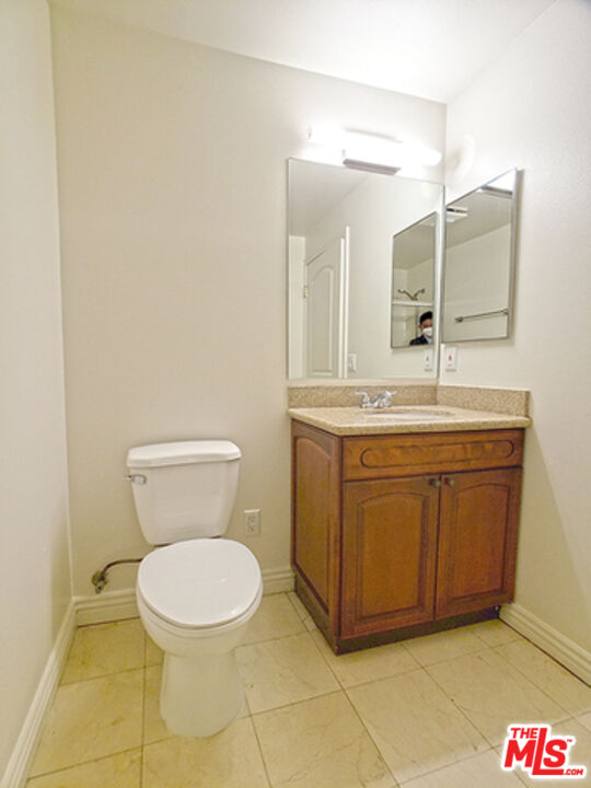 962 Gramercy Drive, Unit 102 Los Angeles, CA 90019 - Photo 6 of 20 a bathroom with a toilet sink and mirror