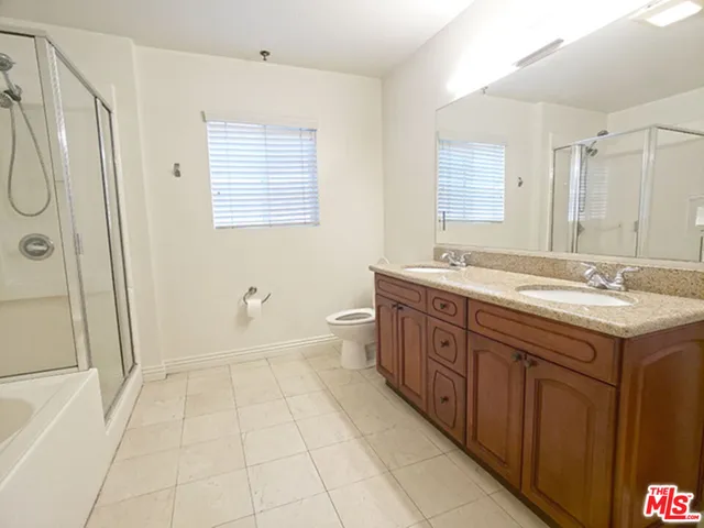 a spacious bathroom with a granite countertop sink a mirror a shower and a bathtub