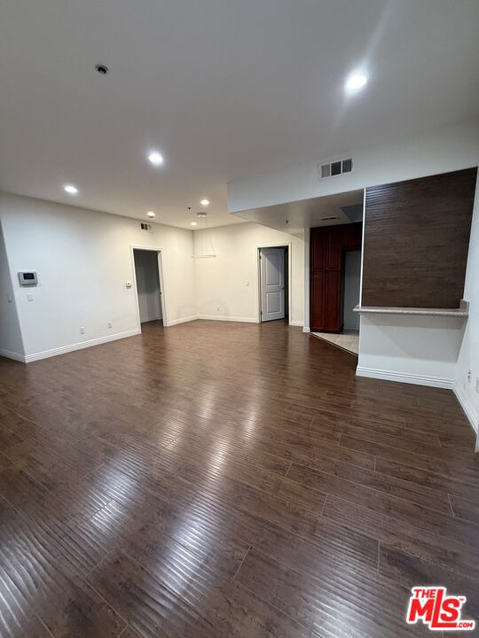 962 Gramercy Drive, Unit 102 Los Angeles, CA 90019 - Photo 10 of 20 a view of an empty room with wooden floor and fire place