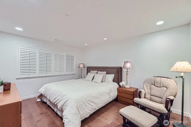 a bedroom with a large bed and a potted plant
