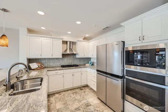 a kitchen with granite countertop a refrigerator stove and sink
