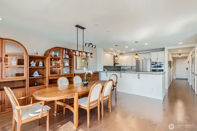 a dining room with stainless steel appliances kitchen island a table and chairs