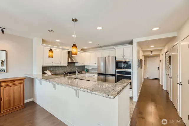 a kitchen with stainless steel appliances granite countertop a sink and a refrigerator
