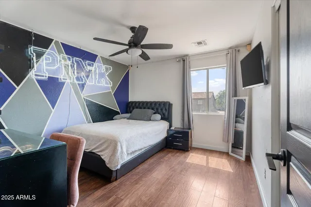 a bedroom with a bed and a flat tv screen on a dresser