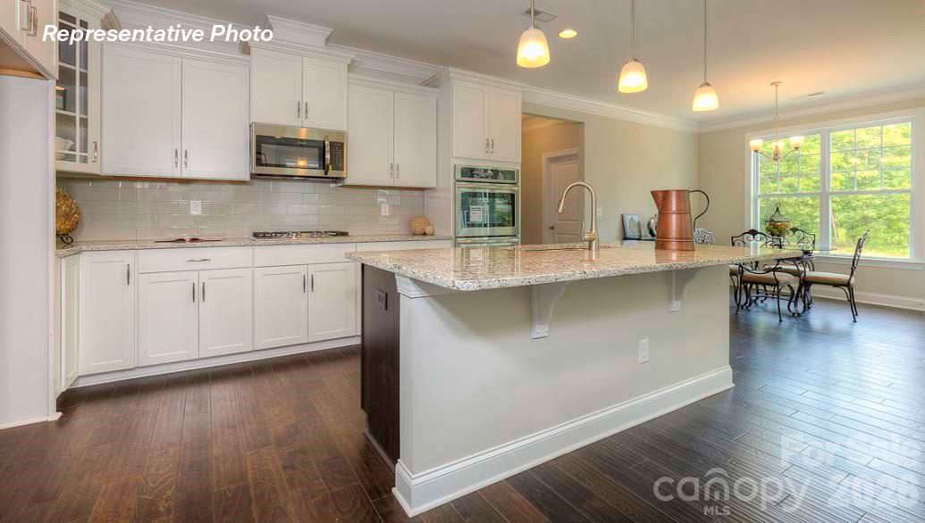 3003 Eclipse Court Indian Trail, NC 28079 - Photo 15 of 48 a kitchen with stainless steel appliances granite countertop a stove a sink and a microwave