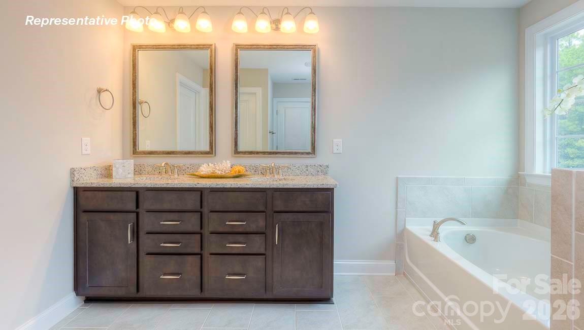 3003 Eclipse Court Indian Trail, NC 28079 - Photo 34 of 48 a bathroom with a tub double vanity sink and a large mirror