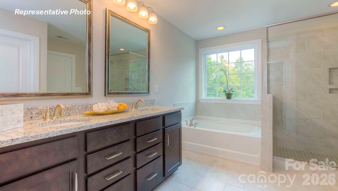 3003 Eclipse Court Indian Trail, NC 28079 - Photo 35 of 48 a bathroom with a tub sink and mirror