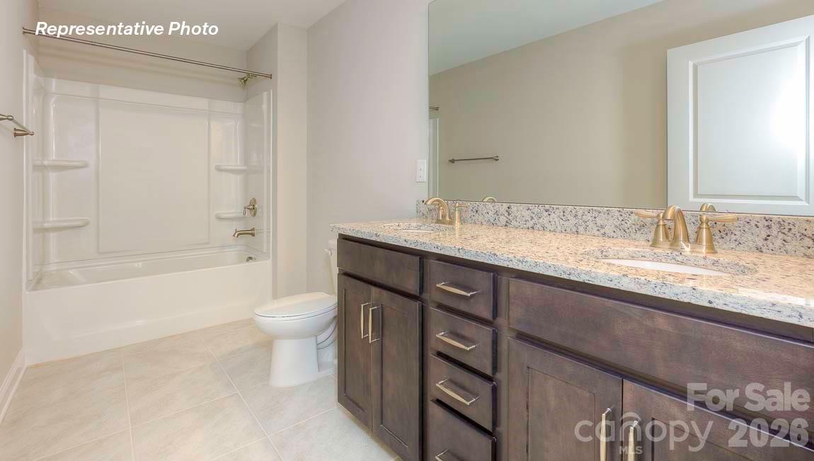 3003 Eclipse Court Indian Trail, NC 28079 - Photo 42 of 48 a bathroom with a granite countertop sink a toilet and shower