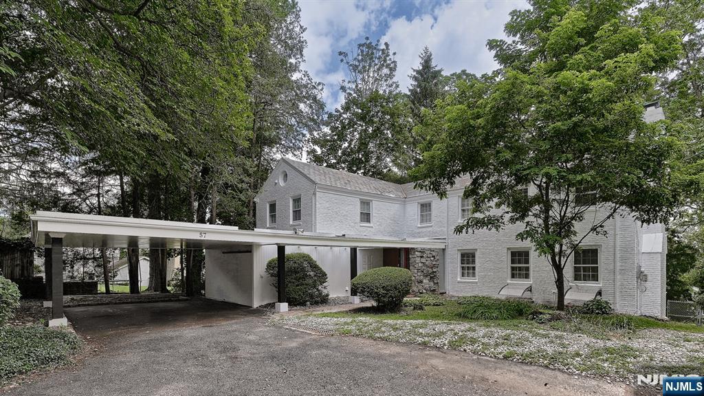 a view of house with a large tree and a yard