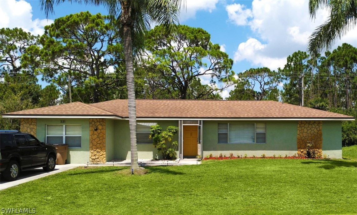 331 Delaware Road Lehigh Acres, FL 33936 - Photo 1 of 22 a view of a house with a yard and sitting area