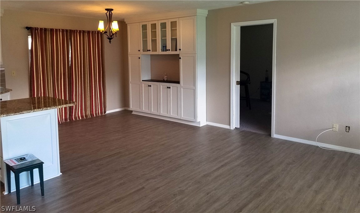 331 Delaware Road Lehigh Acres, FL 33936 - Photo 8 of 22 an empty room with wooden floor and windows