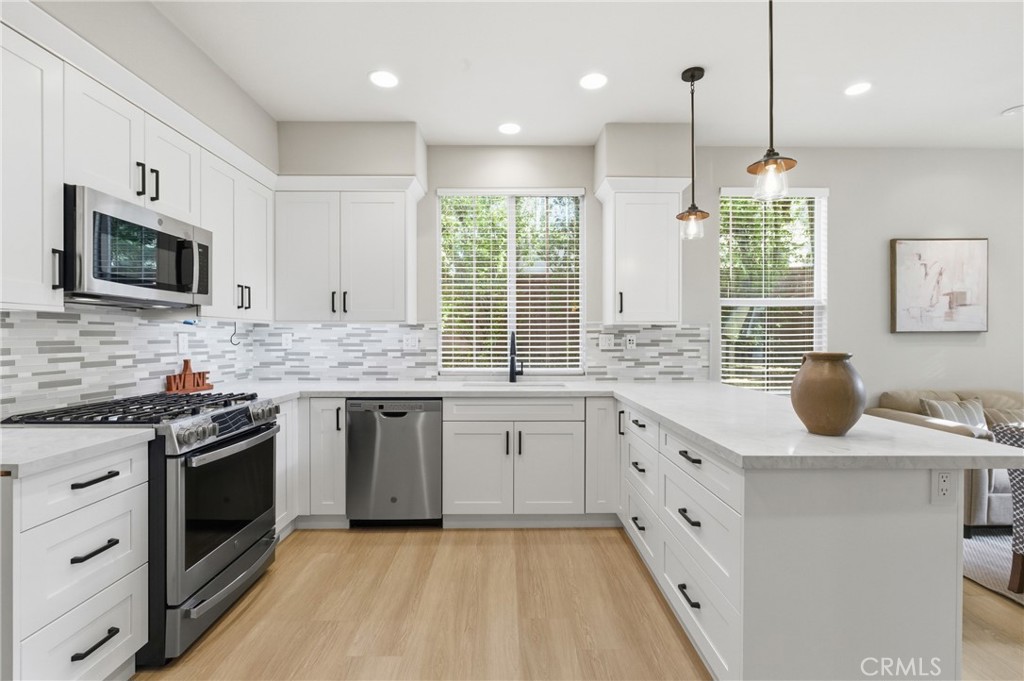 76 Kyle Court Ladera Ranch, CA 92694 - Photo 13 of 60 a kitchen with granite countertop kitchen island white cabinets stainless steel appliances a sink and a window