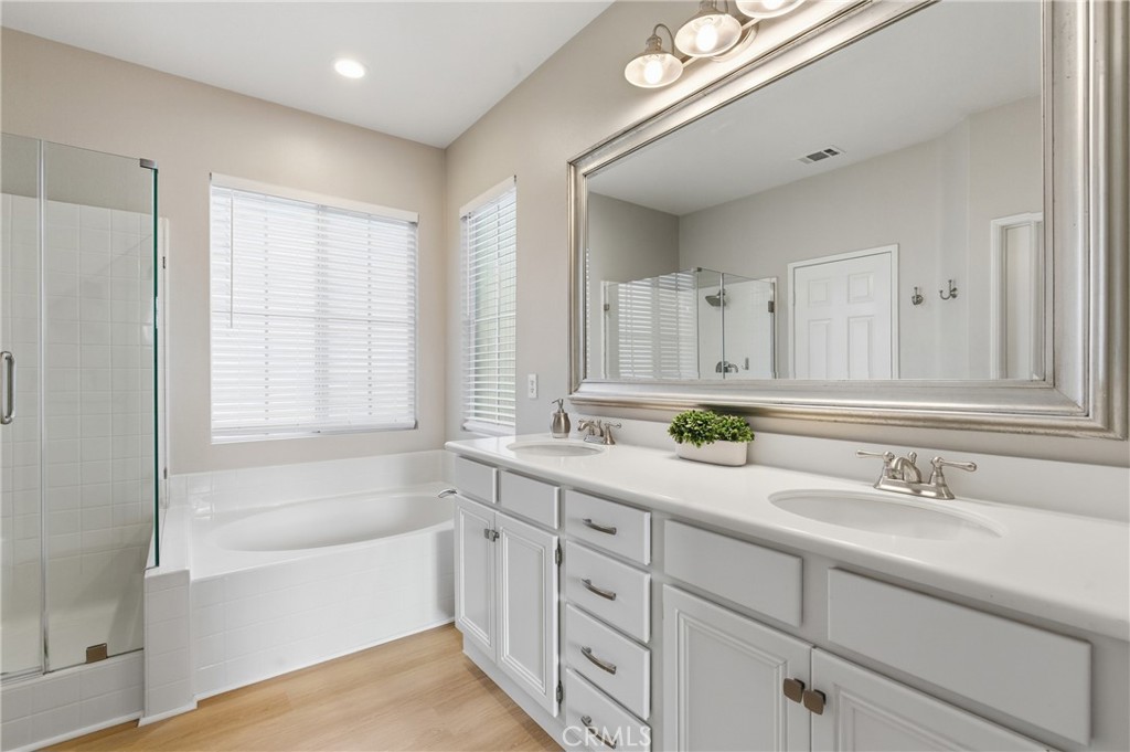 76 Kyle Court Ladera Ranch, CA 92694 - Photo 35 of 60 a bathroom with a bathtub a double vanity sink and mirror