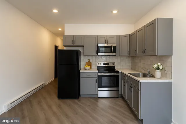 a kitchen with stainless steel appliances a refrigerator a stove a microwave a sink and cabinets