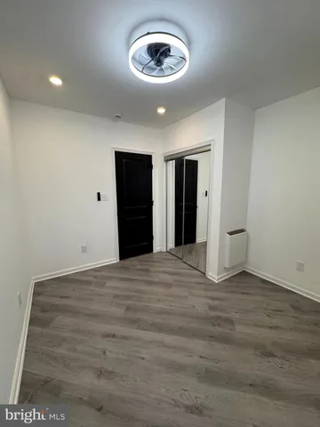 a view of an empty room with closet and a window