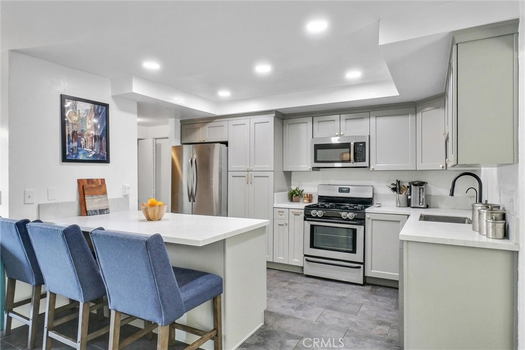 255 Scenic Way Brea, CA 92821 - Photo 11 of 57 a kitchen with stainless steel appliances granite countertop a stove a sink a microwave a refrigerator with a dining table and chairs