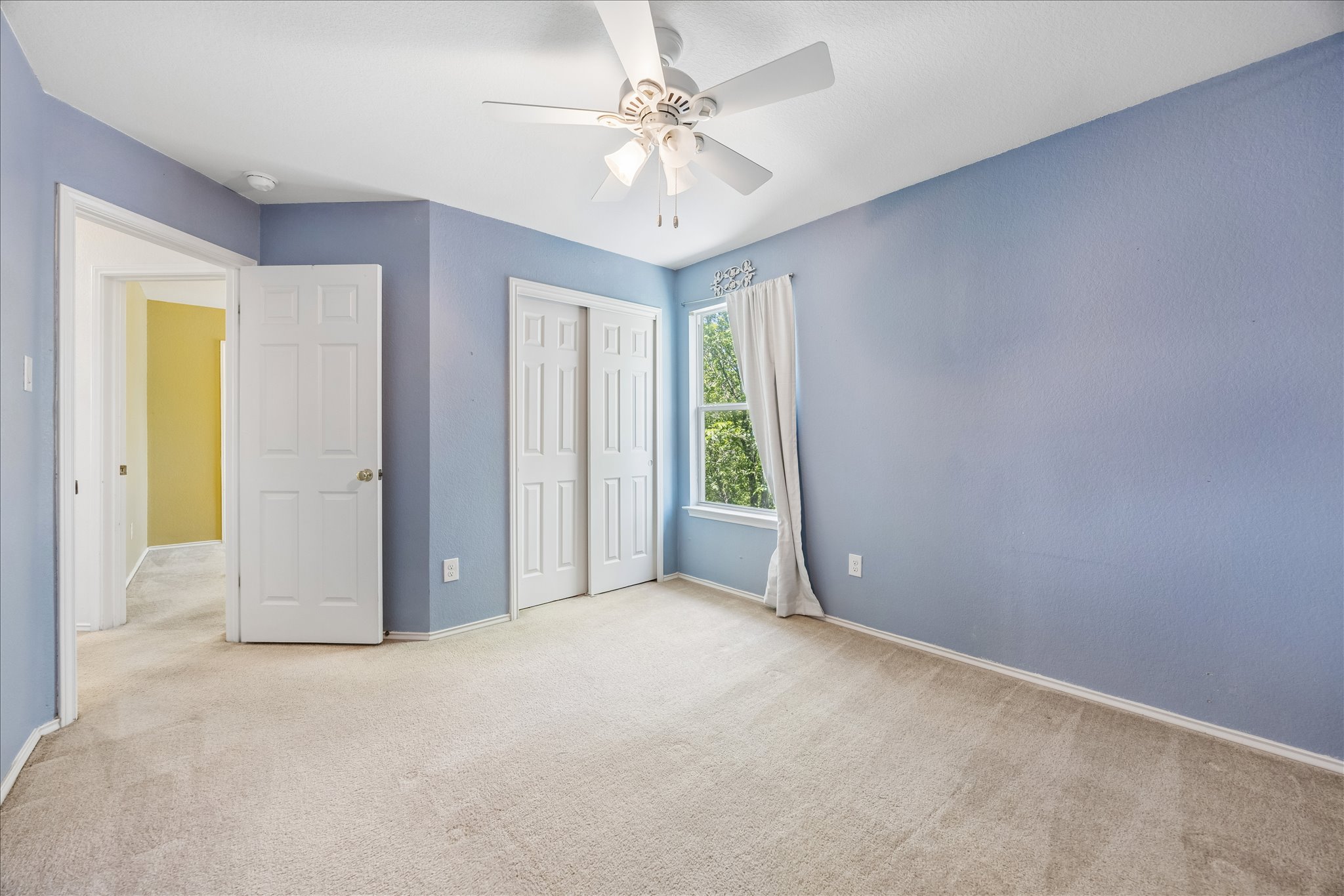 338 Spring Branch Loop Kyle, TX 78640 - Photo 21 of 36 A comfortable bedroom with carpeted floors and a window offering views of the outdoors.
