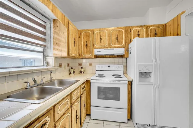 a kitchen with stainless steel appliances white cabinets and a window