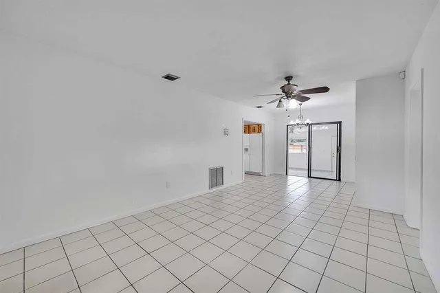 a view of a kitchen with a refrigerator a stove top oven and cabinets