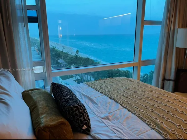 a bedroom with a bed and a balcony view