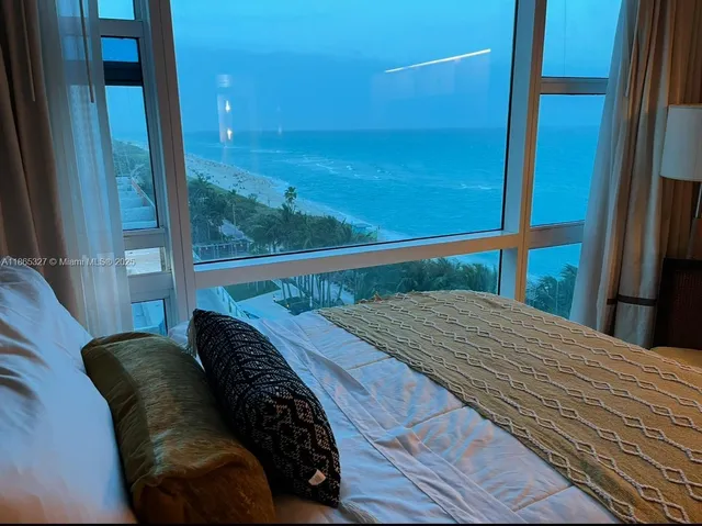a bedroom with a bed and a balcony view