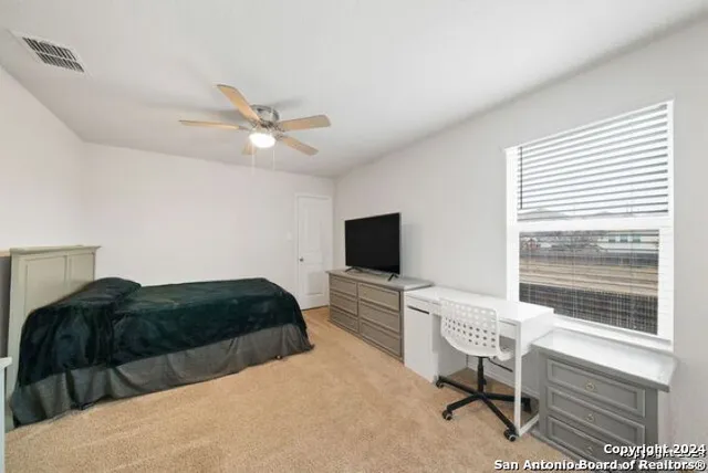 a bedroom with a bed window and a desk