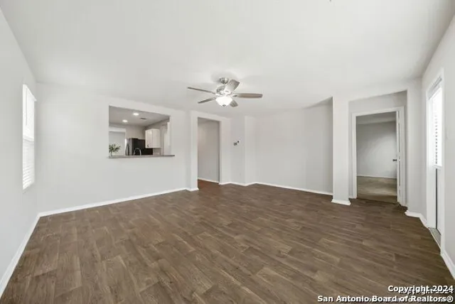 a view of a big room with wooden floor and a ceiling fan