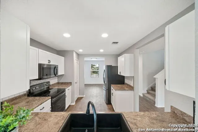 a kitchen with sink refrigerator and stove