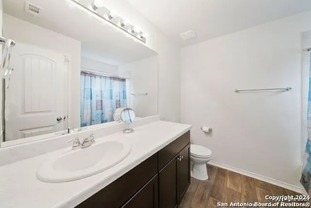 a bathroom with a sink a toilet and a mirror