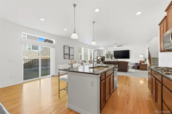 a kitchen with stainless steel appliances granite countertop a sink stove and wooden floor