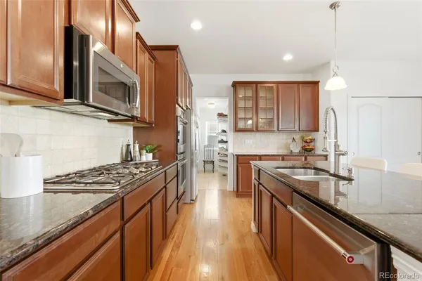 a kitchen with stainless steel appliances sink stove microwave and cabinets