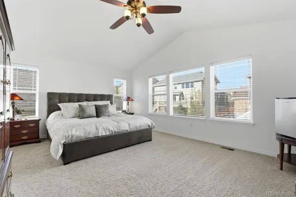 a spacious bedroom with a bed a chandelier and a window