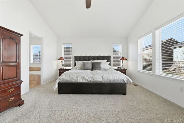 a spacious bedroom with a bed and wooden floor