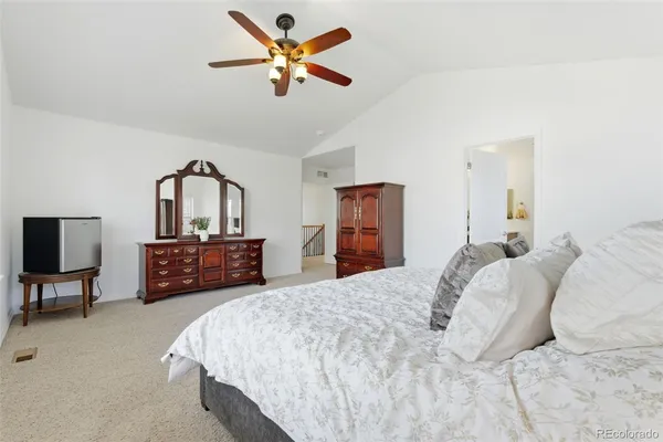 a bedroom with a bed chandelier dresser and a window