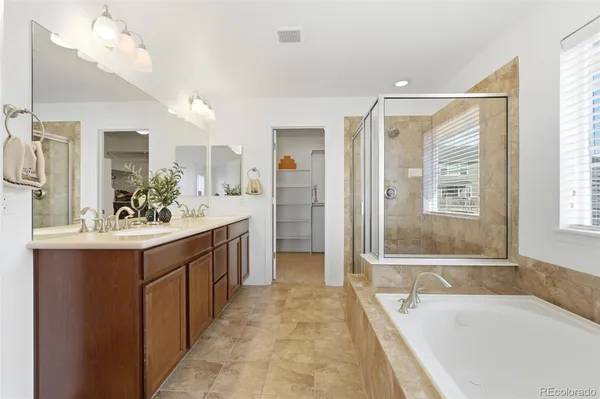 a spacious bathroom with a bathtub sink and mirror
