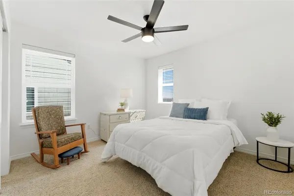 a bedroom with a bed a chair and a chandelier