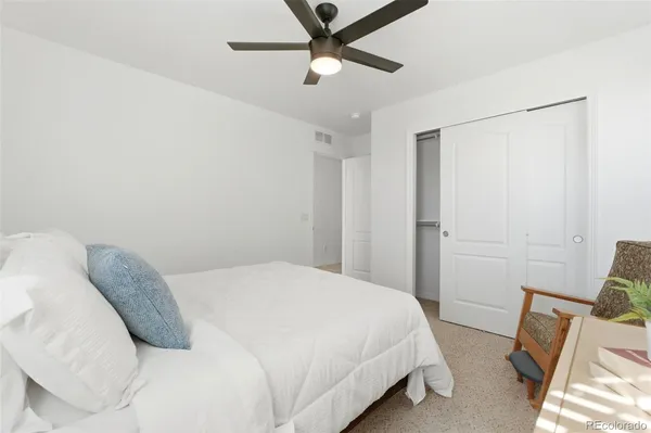 a bedroom with a bed and a ceiling fan