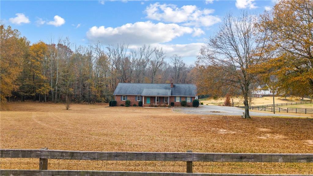 4775 Sewell Road Cumming, GA 30028 - Photo 1 of 1 a front view of a house with a yard and trees