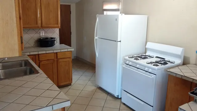 a kitchen with a refrigerator and a stove top oven