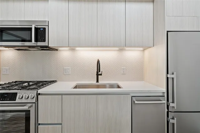 a kitchen with appliances a sink and cabinets