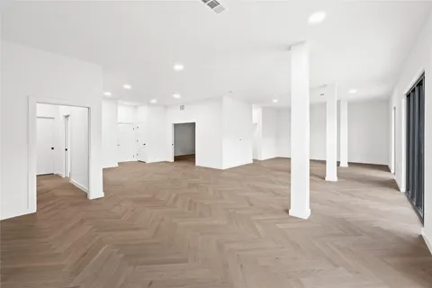 a view of an empty room and a kitchen