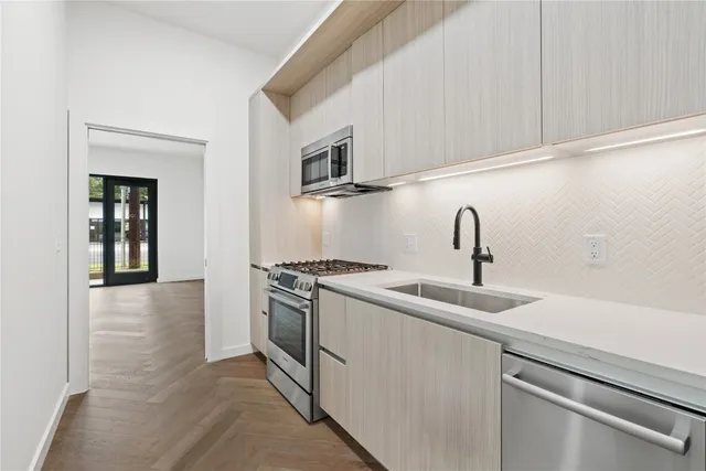 a kitchen with stainless steel appliances granite countertop a sink and a stove