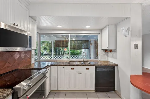 a kitchen with stainless steel appliances kitchen island granite countertop a stove a sink and a microwave