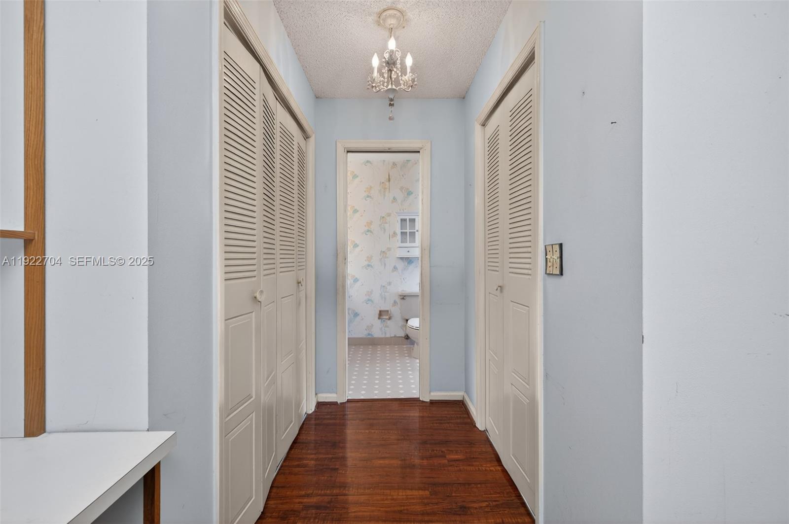 969 Northwest 8th Street Boca Raton, FL 33486 - Photo 17 of 38 a view of a hallway with wooden floor and chandelier