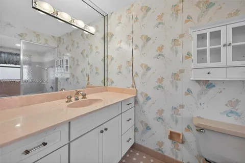 a bathroom with a granite countertop sink a toilet and shower