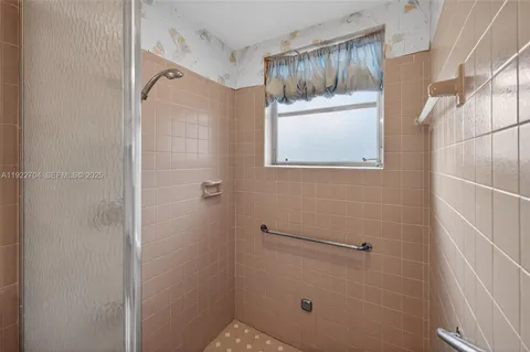 a bathroom with a window and a shower