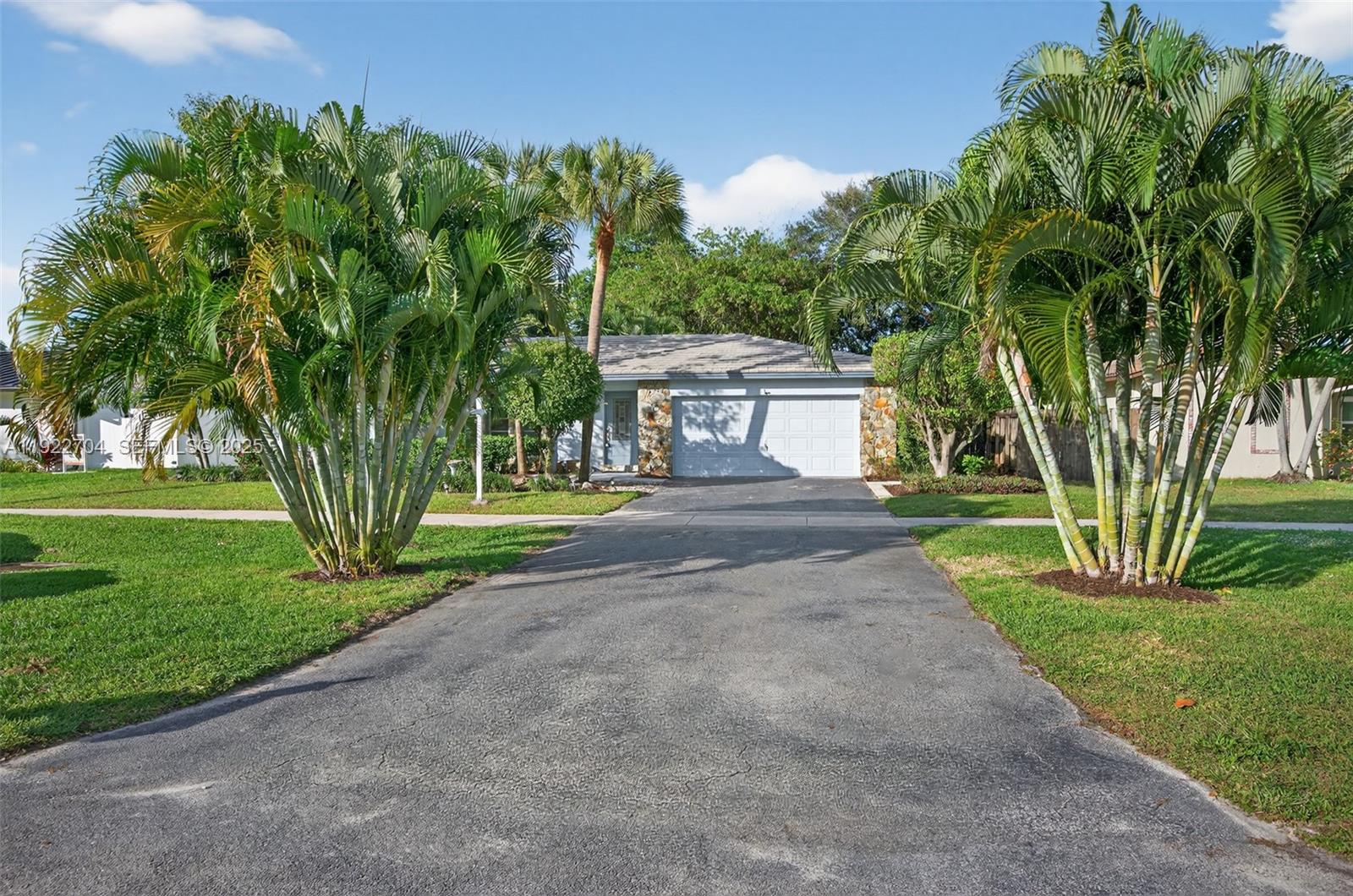969 Northwest 8th Street Boca Raton, FL 33486 - Photo 2 of 38 a view of a house with a big yard and palm trees